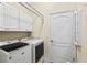 Practical laundry room equipped with modern washer and dryer and ample storage space at 10816 O Meara Way, Englewood, FL 34223