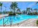 Large swimming pool area with clear blue water, lounge chairs, tropical landscaping, and clubhouse at 10816 O Meara Way, Englewood, FL 34223