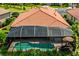 Aerial view of the property featuring a screened-in pool and tile roof at 1358 Cielo Ct, North Venice, FL 34275