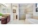 Elegant bathroom featuring dual vanity sinks, a walk-in shower, and a soaking tub at 1358 Cielo Ct, North Venice, FL 34275