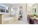 Serene bathroom boasts a soaking tub, tiled floors, and a charming view of the outdoors at 1358 Cielo Ct, North Venice, FL 34275