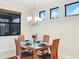 Dining room with modern chandelier, wood table, and view to rear yard at 1358 Cielo Ct, North Venice, FL 34275