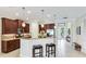 Kitchen with granite counters, pendant lights, stainless appliances, and seating at bar, all adjacent to entry at 1358 Cielo Ct, North Venice, FL 34275
