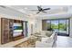 Bright living room with ceiling fan, tile floor, stylish furnishings, and a view of the outdoor pool area at 1358 Cielo Ct, North Venice, FL 34275