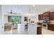 Open living space with a kitchen bar, and a living room with sliding door access to the pool at 1358 Cielo Ct, North Venice, FL 34275