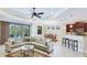 Spacious living area with plush seating, dining table, kitchen bar, and access to outdoor pool at 1358 Cielo Ct, North Venice, FL 34275