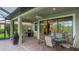 Covered outdoor patio featuring a grill, dining table, and comfortable seating area at 1358 Cielo Ct, North Venice, FL 34275