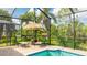 Relaxing poolside retreat with lounge chairs, a straw umbrella, and lush tropical surroundings at 1358 Cielo Ct, North Venice, FL 34275