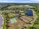 Aerial view of the community park amenities, including a pool, clubhouse, basketball court, playground, and scenic lakes at 14309 Carolina Sky Pl, Lakewood Ranch, FL 34211