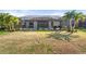 Rear view of the home with a screened-in lanai, sliding glass doors, and lush landscaping around the patio at 14309 Carolina Sky Pl, Lakewood Ranch, FL 34211