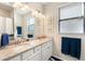 Bright bathroom features a granite countertop, double sinks, and nautical decor at 14309 Carolina Sky Pl, Lakewood Ranch, FL 34211