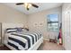 Nautical themed bedroom features a bed, window, and ceiling fan at 14309 Carolina Sky Pl, Lakewood Ranch, FL 34211