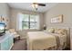 Bedroom features a TV, chair, ceiling fan and a large window at 14309 Carolina Sky Pl, Lakewood Ranch, FL 34211