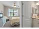 Bedroom features a TV, chair, ceiling fan and a bathroom ensuite at 14309 Carolina Sky Pl, Lakewood Ranch, FL 34211