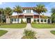 Elegant exterior of a clubhouse with a red tile roof, surrounded by manicured landscaping and palm trees at 14309 Carolina Sky Pl, Lakewood Ranch, FL 34211