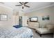 Bright and airy bedroom with ceiling fan, sitting area, and backyard views at 14309 Carolina Sky Pl, Lakewood Ranch, FL 34211