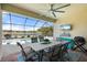 Outdoor patio with dining table, TV, and a serene pool view at 14309 Carolina Sky Pl, Lakewood Ranch, FL 34211
