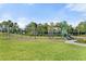 Community playground featuring swings and a slide in a lush green landscape with mature palm trees at 14309 Carolina Sky Pl, Lakewood Ranch, FL 34211