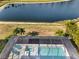 Aerial view of a screened-in pool and spa overlooking a serene lake with palm trees, providing a relaxing outdoor space at 14309 Carolina Sky Pl, Lakewood Ranch, FL 34211