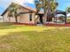 Wide view of the backyard featuring a pool and partial home view with mulch beds and palm trees at 1438 Vermouth Ln, Punta Gorda, FL 33983