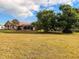 Expansive backyard featuring a screened pool enclosure and mature shade trees at 1438 Vermouth Ln, Punta Gorda, FL 33983