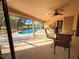 Covered outdoor patio space with ample seating for entertaining with an in-ground pool at 1438 Vermouth Ln, Punta Gorda, FL 33983