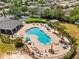 Aerial view of community pool featuring a lounge area, beach volleyball court, clubhouse, and tennis court at 1717 Bonita Bluff Ct, Ruskin, FL 33570