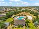 Aerial view of the community pool with a lounge area, tennis court, clubhouse, and beautiful landscaping at 1717 Bonita Bluff Ct, Ruskin, FL 33570