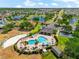 Aerial view of the community pool, including a lounge area, beach volleyball court, and nearby street at 1717 Bonita Bluff Ct, Ruskin, FL 33570