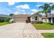 Charming single-story home featuring a two-car garage, well-maintained lawn, and a beautiful palm tree at 1717 Bonita Bluff Ct, Ruskin, FL 33570