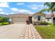 Lovely home featuring a two-car garage, mature landscaping, a brick pathway, and a welcoming entryway at 1717 Bonita Bluff Ct, Ruskin, FL 33570
