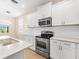 Bright kitchen featuring white cabinets, stainless steel appliances, and granite countertops at 1717 Bonita Bluff Ct, Ruskin, FL 33570