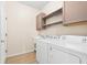 Functional laundry room with washer, dryer, utility sink, and storage shelves at 1717 Bonita Bluff Ct, Ruskin, FL 33570