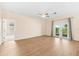 Open living area with ceiling fan, wood floors, and patio access with views of the backyard at 1717 Bonita Bluff Ct, Ruskin, FL 33570
