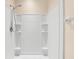Bright shower featuring white tiled walls and built-in shelving at 1717 Bonita Bluff Ct, Ruskin, FL 33570