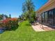 Backyard featuring a patio, lush lawn, tropical plants, and a tranquil water view at 1720 Kestral Park S Way # 49, Sarasota, FL 34231