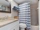 Bright bathroom featuring a shower-tub, vanity with granite counters, and a decorative mirror and towel storage at 1720 Kestral Park S Way # 49, Sarasota, FL 34231