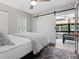 Bedroom with a queen bed, ceiling fan, plantation shutters, and a view to the Florida Room via sliding barn doors at 1720 Kestral Park S Way # 49, Sarasota, FL 34231