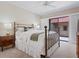 This bedroom features a metal bed frame, bedside tables and sliding doors to a patio at 1720 Kestral Park S Way # 49, Sarasota, FL 34231