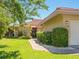 Inviting front entrance with a brick pathway, manicured bushes, and red terracotta roof at 1720 Kestral Park S Way # 49, Sarasota, FL 34231