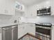 Stylish kitchen with stainless steel appliances, white cabinetry, granite countertops, tile backsplash, and hardwood floors at 1720 Kestral Park S Way # 49, Sarasota, FL 34231