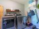 Laundry room featuring a washer and dryer, shelving for storage, and a utility sink at 1720 Kestral Park S Way # 49, Sarasota, FL 34231