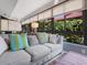 Comfortable sunroom featuring large windows with garden views and neutral toned furniture at 1720 Kestral Park S Way # 49, Sarasota, FL 34231