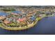 Aerial view showcasing IslandWalk's lakeside recreational amenities including a clubhouse, pool, and tennis courts at 19138 Kirella St, Venice, FL 34293