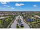 Scenic aerial view of community entrance with lush landscaping, serene ponds, and picturesque single-Gathering homes at 19138 Kirella St, Venice, FL 34293