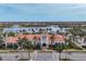 Aerial view showcases the clubhouse, lush landscaping, nearby lake, and surrounding IslandWalk neighborhood at 19138 Kirella St, Venice, FL 34293