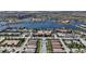 Wide aerial view showcasing the community's many homes surrounding a large lake with palm trees and a pool area at 19138 Kirella St, Venice, FL 34293