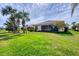 Spacious backyard with a well-maintained lawn, mature landscaping, and a screened-in lanai at 19138 Kirella St, Venice, FL 34293