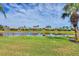 Picturesque backyard view featuring a serene lake, well-manicured lawn, and neighboring homes at 19138 Kirella St, Venice, FL 34293