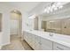 Bright bathroom featuring a double sink vanity, large mirror and walk-in shower at 19138 Kirella St, Venice, FL 34293